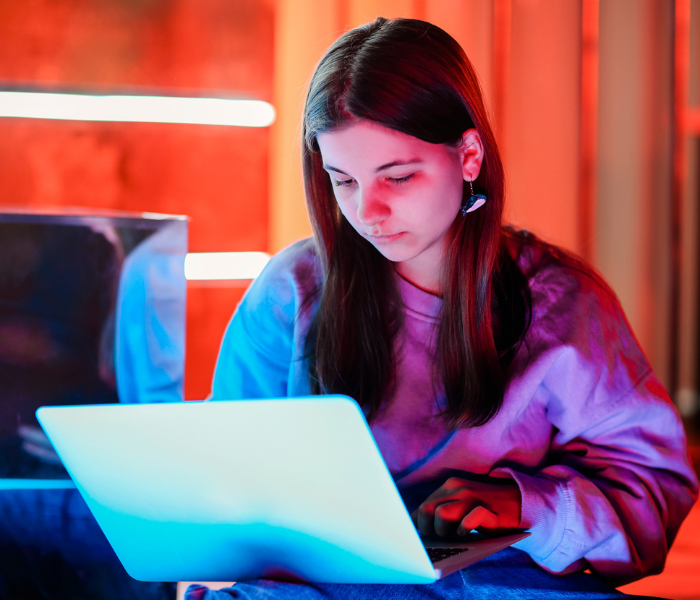 Children using tablets and smartphones at home, representing online safety risks such as cyberbullying, online predators, and digital identity threats