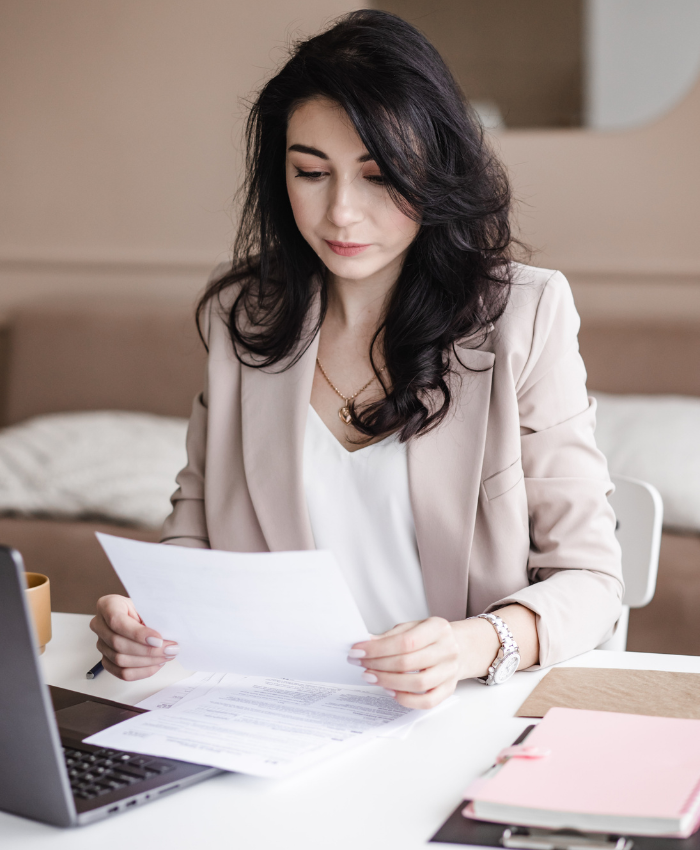 Woman reviewing financial documents to create a retirement and investment plan.