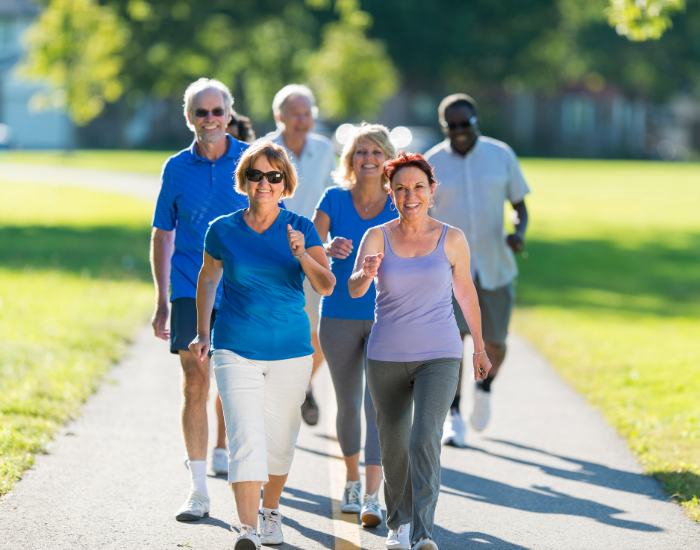 Group of people walking together in a park, enjoying light exercise and an active lifestyle