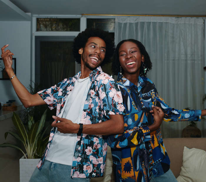 Husband and wife dancing together in a living room, enjoying a joyful and active moment